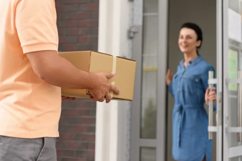 woman receiving package from delivery person at ho utc
